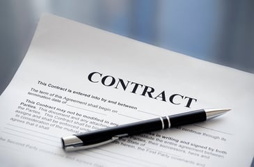 A stock photo of a contract with a black pen laying on it.
